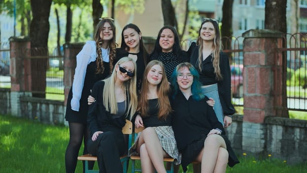 Cheerful students posing together on a bench in the schoolyard, celebrating their school day with joy and camaraderie