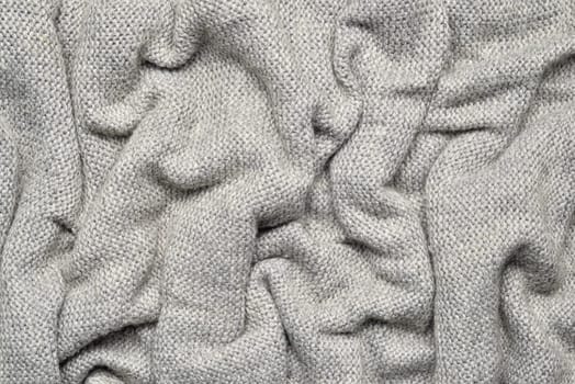 Close up texture of light gray crumpled woven fabric with a subtle pattern of evenly spaced tiny dots, providing a soft, neutral background ideal for design and creative projects.