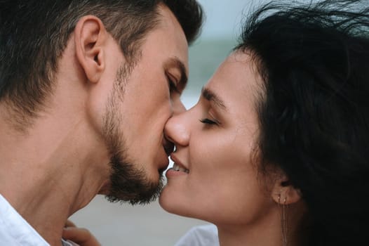 couple in love kissing on the beach by the sea in summer close-up