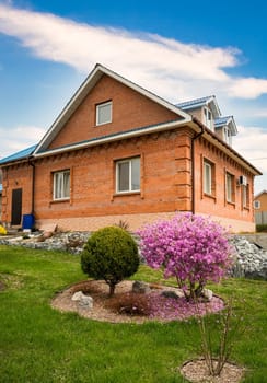 brick house near bush of rhododendron whithout people
