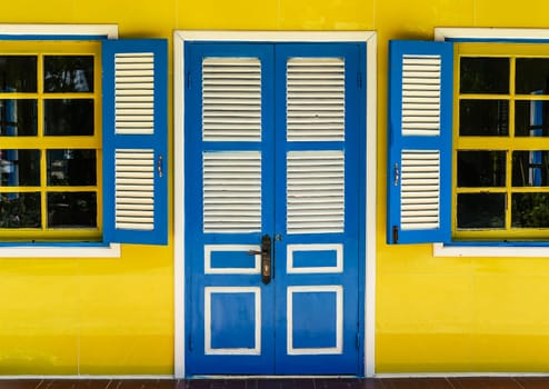 Closed wooden door and opened windows in positive colors