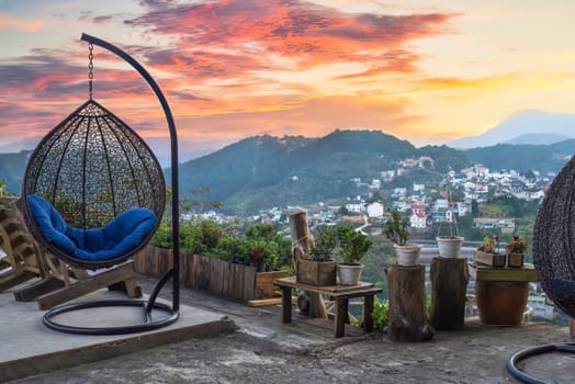 Hanging chair with pillow against sunset view and mountains in Da Lat city in Vietnam