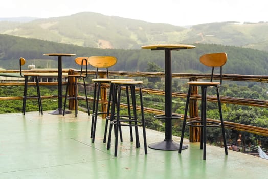 Coffee tables and chairs on a viewpoint overlooking Da Lat mountains in Vietnam