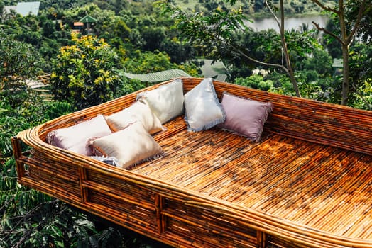 Creative objects in Vietnam wooden bed with cozy pillows against vietnamese landscape of Da Lat city