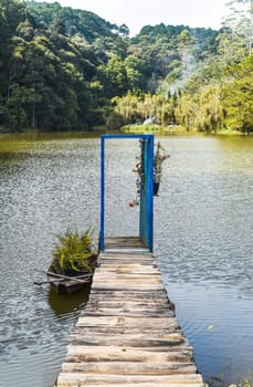 Pier with opened door toward lake and pine forest like metaphor