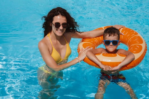 happy young mother and child boy son in swimming pool at a hotel on vacation at a resort in the summer