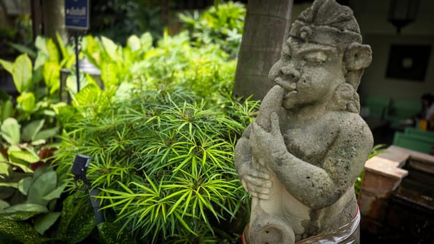 Garden Gnome traditional stone statue situated in a tranquil tropical garden, surrounded by vibrant foliage and artistic decor, harmonizing with the natural beauty of its environment. Good for Background