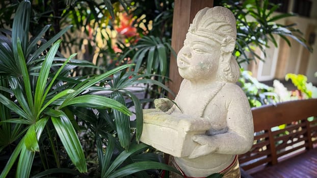 Garden Gnome traditional stone statue situated in a tranquil tropical garden, surrounded by vibrant foliage and artistic decor, harmonizing with the natural beauty of its environment. Good for Background