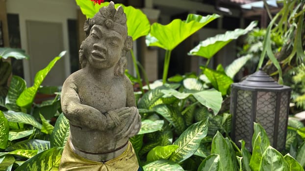 Garden Gnome traditional stone statue situated in a tranquil tropical garden, surrounded by vibrant foliage and artistic decor, harmonizing with the natural beauty of its environment. Good for Background
