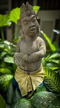 Garden Gnome traditional stone statue situated in a tranquil tropical garden, surrounded by vibrant foliage and artistic decor, harmonizing with the natural beauty of its environment. Good for Background