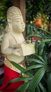 Garden Gnome traditional stone statue situated in a tranquil tropical garden, surrounded by vibrant foliage and artistic decor, harmonizing with the natural beauty of its environment. Good for Background