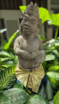 Garden Gnome traditional stone statue situated in a tranquil tropical garden, surrounded by vibrant foliage and artistic decor, harmonizing with the natural beauty of its environment. Good for Background