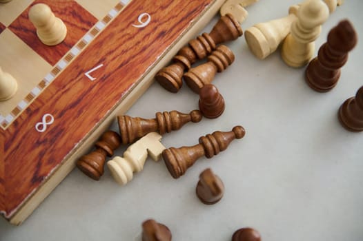 A chessboard with wooden-colored squares and scattered chess pieces creates a dynamic composition.