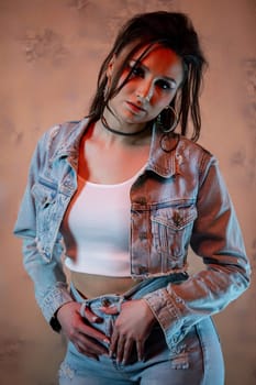 A fashionable young woman confidently poses in a stylish denim outfit paired with a chic crop top, exuding confidence