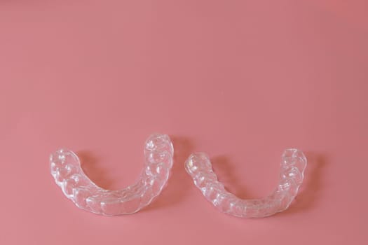 Transparent aligners, invisalign bracer smile isolated on pastel light pink background