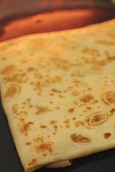 Morning breakfast thin pancakes with ham and cheese in an envelope are placed on a serving surface in a restaurant