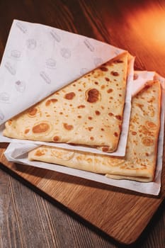 Morning breakfast thin pancakes with ham and cheese in an envelope are placed on a serving surface in a restaurant
