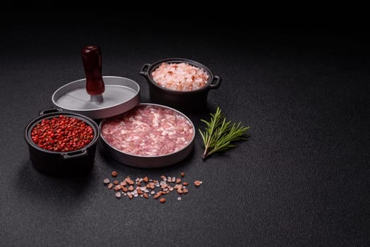 Metal press for making minced meat cutlets for burgers on a dark concrete background