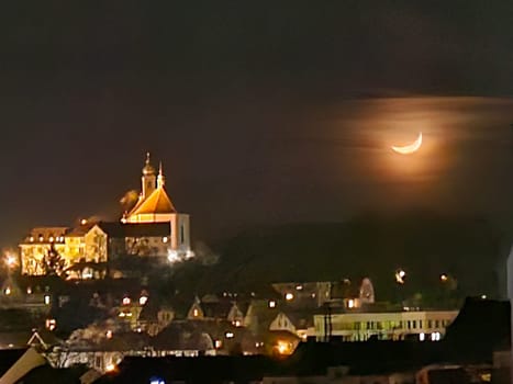 Franziskanerkloster Frauenberg mit Stiftskirche in Fulda, Deutschland, bei Nacht im Mondlicht und hellen Lichtern, in der Ferne. High quality photo