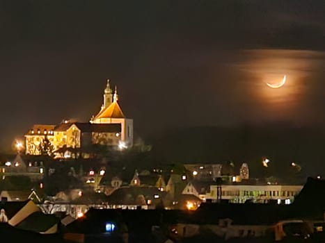 Franziskanerkloster Frauenberg mit Stiftskirche in Fulda, Deutschland, bei Nacht im Mondlicht und hellen Lichtern, in der Ferne. High quality photo