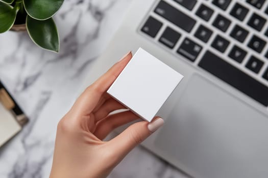 A woman is holding a white box in front of a laptop. The box is empty and the laptop is open. The scene suggests a moment of contemplation or decision-making