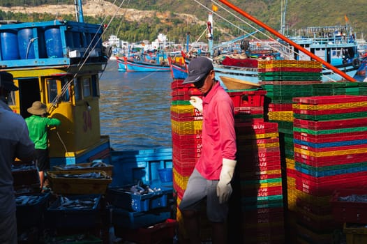 Vietnamese workers working at the fish market. In the morning, these people were unloading boxes of fresh fish. Vietnam, Nha Trang - September 8, 2024