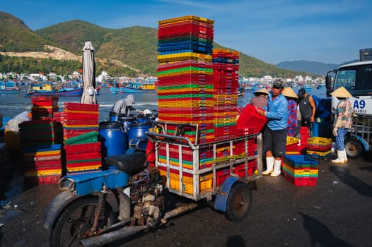 Vietnamese people at the fish market load empty boxes after selling fresh fish Vietnam. Nha Trang - September 8, 2024.