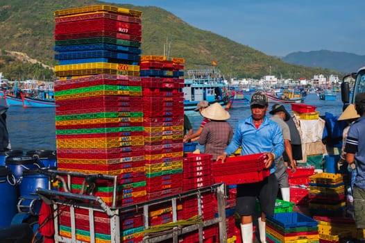 Vietnamese people at the fish market load empty boxes after selling fresh fish Vietnam. Nha Trang - September 8, 2024.