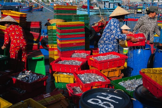 Local Vietnamese residents work at the fish market, unloading boxes from ships. Vietnam, Nha Trang - September 8, 2024