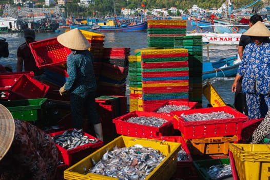 Local Vietnamese residents work at the fish market, unloading boxes from ships. Vietnam, Nha Trang - September 8, 2024