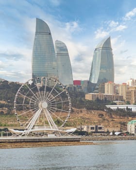 The skyline of Baku, Azerbaijan, characterized by the presence of flame towers, which stand alongside the Baku Eye Ferris wheel