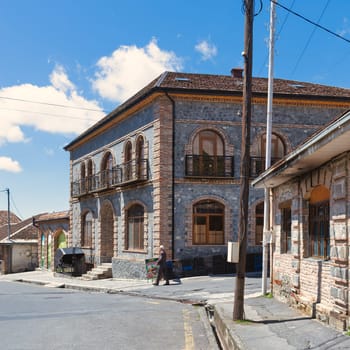 Shaki, Azerbaijan - May 15, 2024: A meticulously constructed stone building exemplifies traditional Azerbaijani architecture, characterized by its intricate arches and balconies, against an azure sky