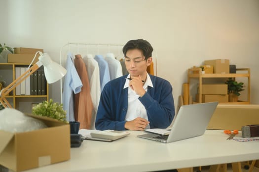 Focused online seller working on a laptop planning marketing strategies.