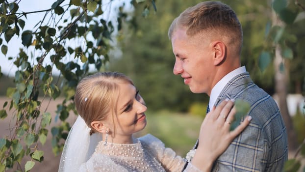 Romantic newlyweds embracing beneath birch tree, capturing intimate wedding moment symbolizing deep emotional connection