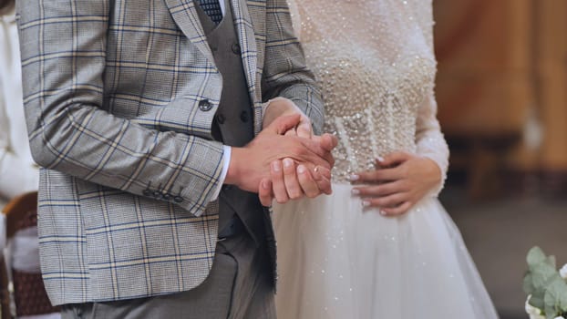 Couple exchanging vows, holding hands, during wedding ceremony, symbolizing unity and love