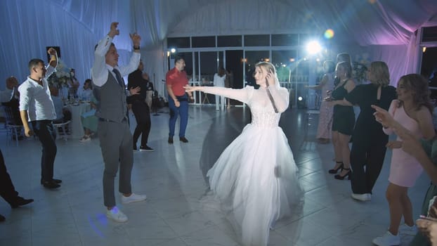 Bride and groom dancing and celebrating their wedding day with friends and family at the reception