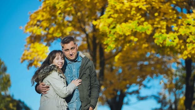 Cheerful couple sharing intimate connection amid colorful autumn foliage, embracing seasonal warmth and love