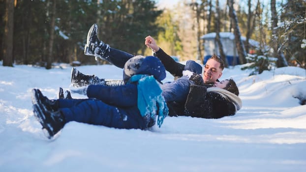 Happy family enjoying a winter day, playing in the snow, laughing together and creating joyful memories in a beautiful, frosty landscape