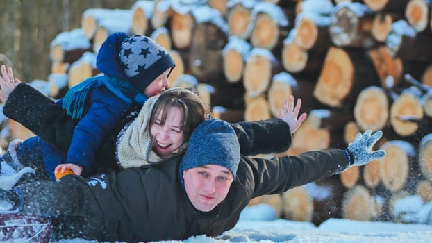 Cheerful family playing, laughing, sledding through snowy winter landscape, bonding with shared winter fun