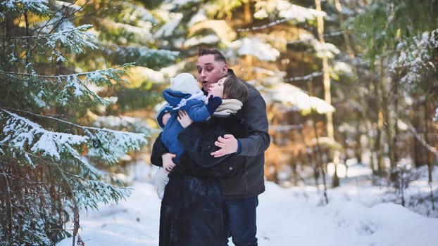 Parents joyfully holding and playing with their baby in a snowy winter forest, embracing the beauty of a delightful outdoor day