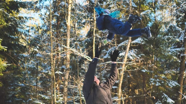 Father and child playing together in snowy winter forest, enjoying quality time in nature
