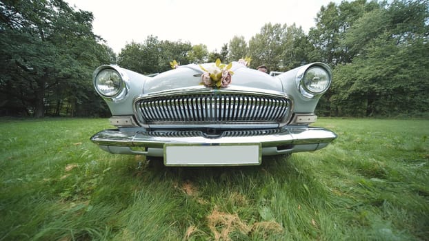 Elegant volga m21 parked on a grass field, decorated with flowers for a wedding celebration, exuding vintage charm and romance