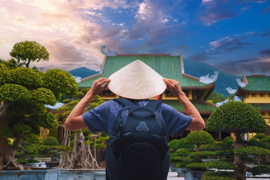 back of male tourist traveler at a Buddhist temple at Linh Ung Pagoda in Da Nang in Vietnam. Concept of travel and tourism in Asia