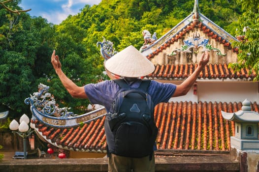 back of a male tourist traveler at the temple on the Buddhist pagoda in Da Nang, Vietnam. Travel and tourism in Asia