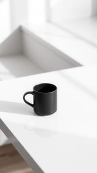 Black cup on a white table. Minimalist style
