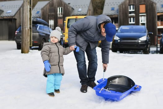 The father with son sledding in the snow