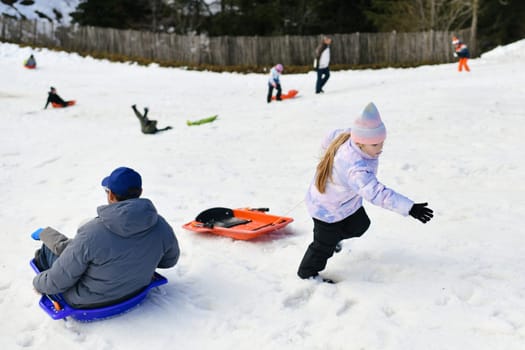The father with children sledding in the snow
