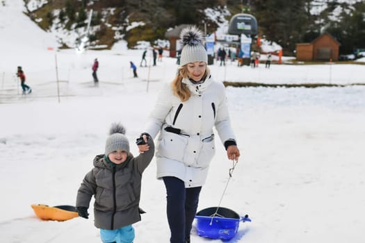 The mother with child sledding in the snow