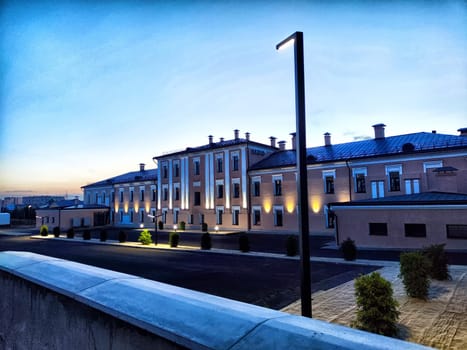 Orenburg, Russia - July 19, 2024 - Dusk falls over Orenburg, revealing a beautifully lit historical building with modern touches, set against a tranquil evening sky.
