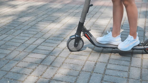 Teenager riding electric scooter in park on sunny summer day, enjoying sustainable transportation